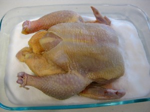chicken in a baking pan filled with salt