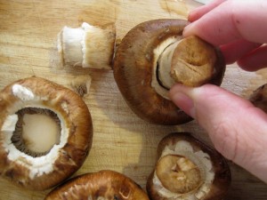 twisting off stems from portobello mushrooms