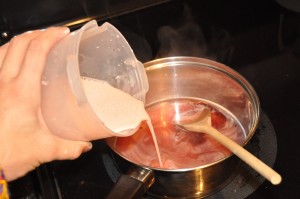 adding ingredients to make strawberry pudding