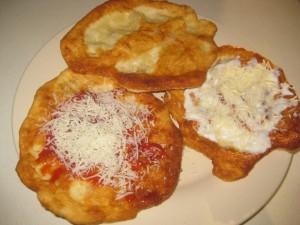 langosh topped with ketchup, sour cream, cheese and garlic