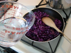 preparing red cabbage side dish by frying and steaming it