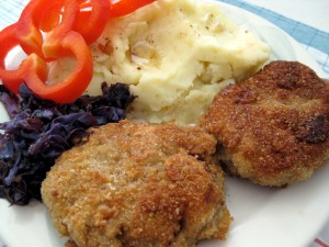 Slovak fried meat hamburger pattie fasirka served with mashed potatoes, red cabbage and vegetables