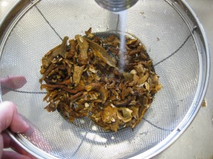rinsing dried mushrooms in a sink