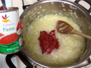 adding tomato pasted to cabbage soup