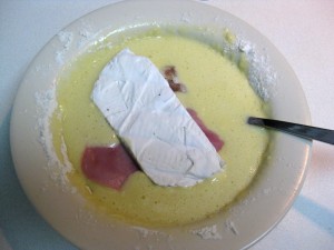 pork schnitzel being breaded in dough